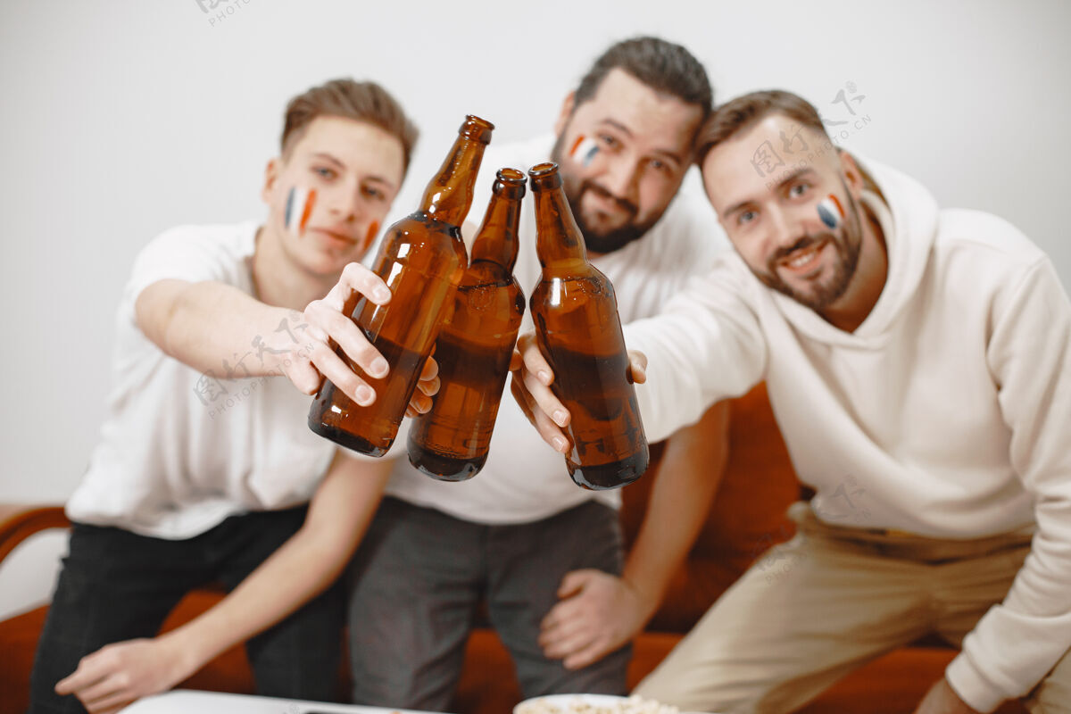 啤酒足球迷坐在客厅的沙发上喝啤酒沙发家伙成功