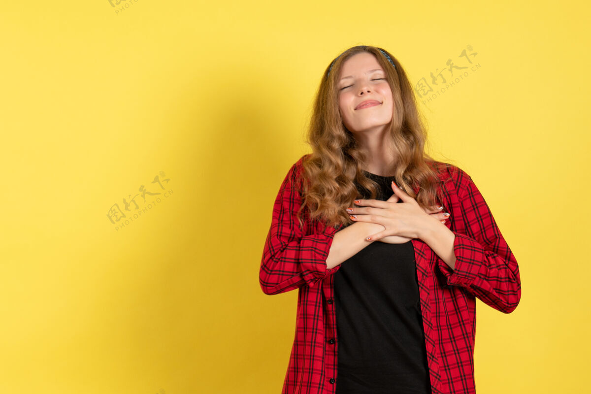 衬衫正面图身着红色格子衬衫的年轻女性站在黄色背景上 触动着她的心 女孩们是人类色彩的模范女人人年轻女性成人