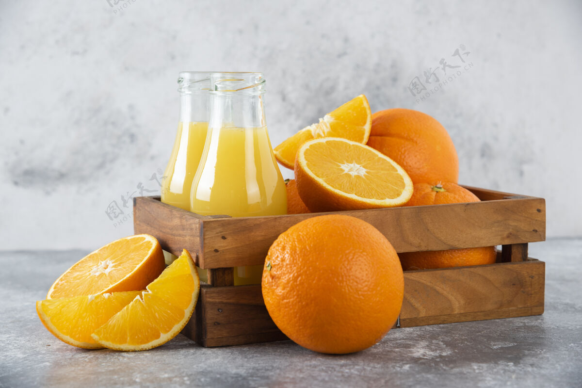 多汁石头桌上放着一个木制的旧盒子 里面装满了桔子和玻璃罐的果汁异国情调橙子新鲜