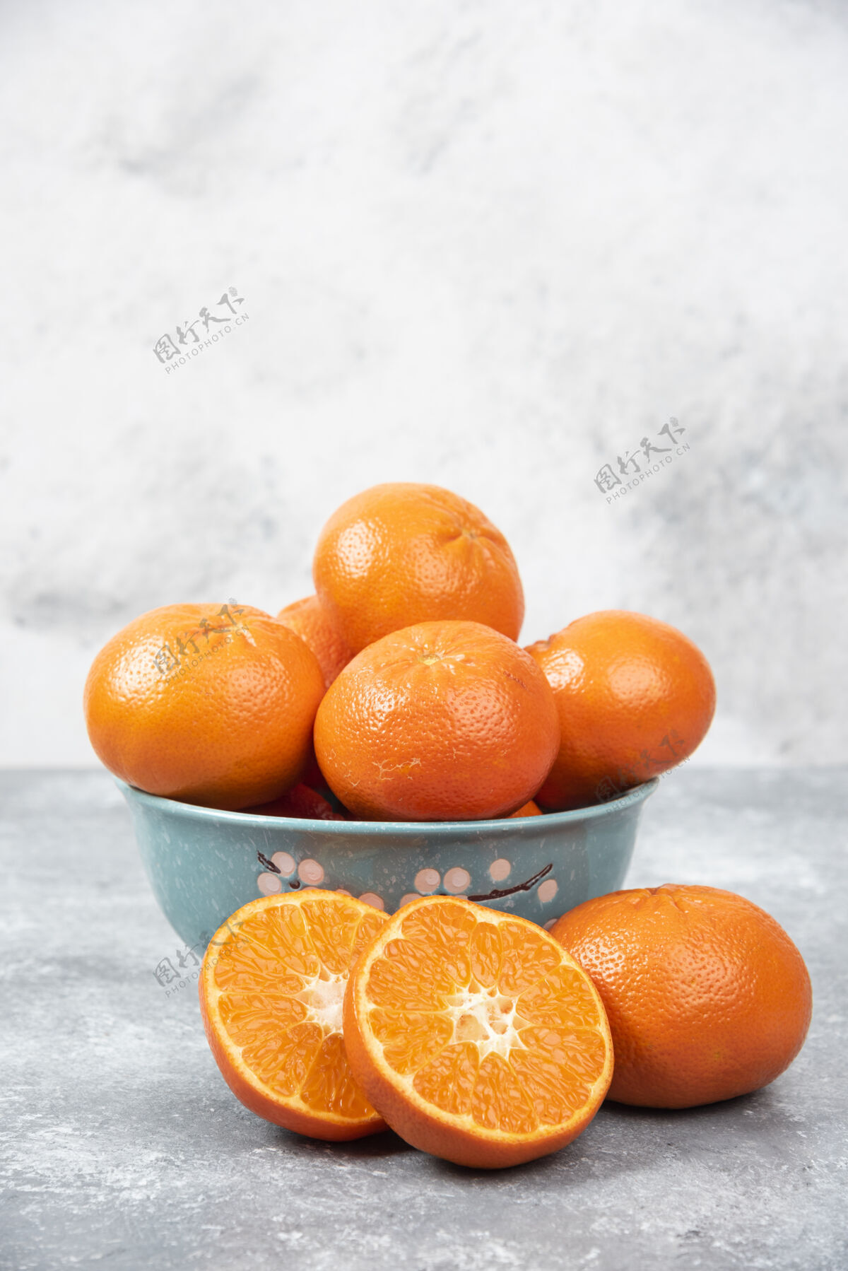 半把新鲜多汁的橙子全切在一个放在石桌上的碗里生的柑橘成熟