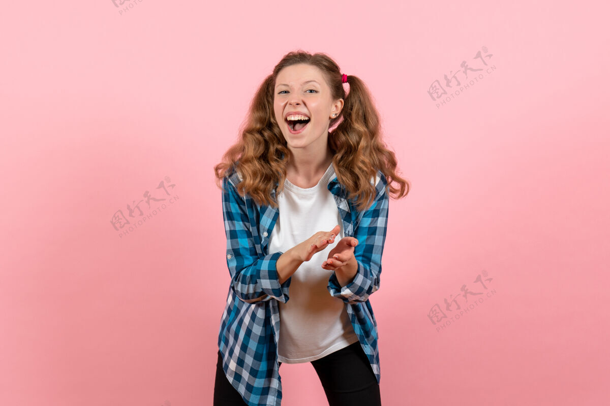 情绪正面图：穿着格子衬衫的年轻女性在粉色背景上摆姿势模特情感儿童青年彩色女人头发格子姿势
