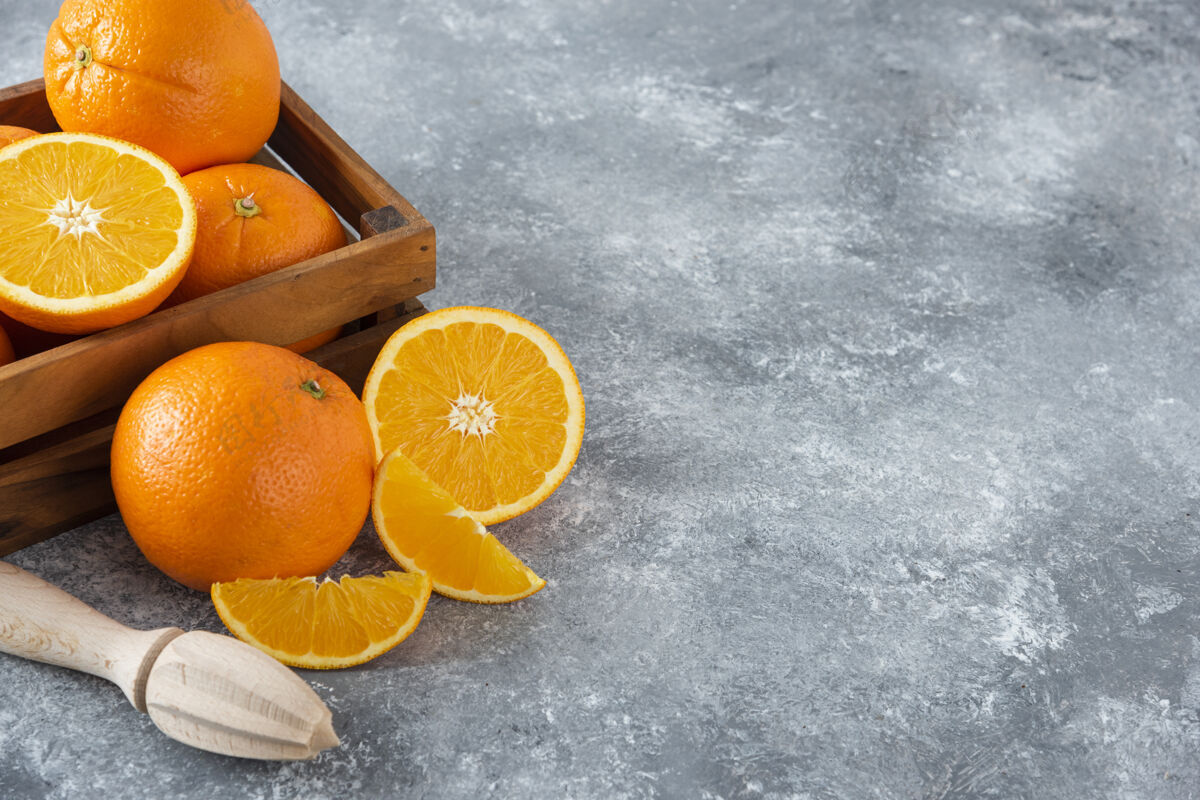 甜点石桌上放着一个木制的旧盒子 里面装满了多汁的橙子背景水果味道