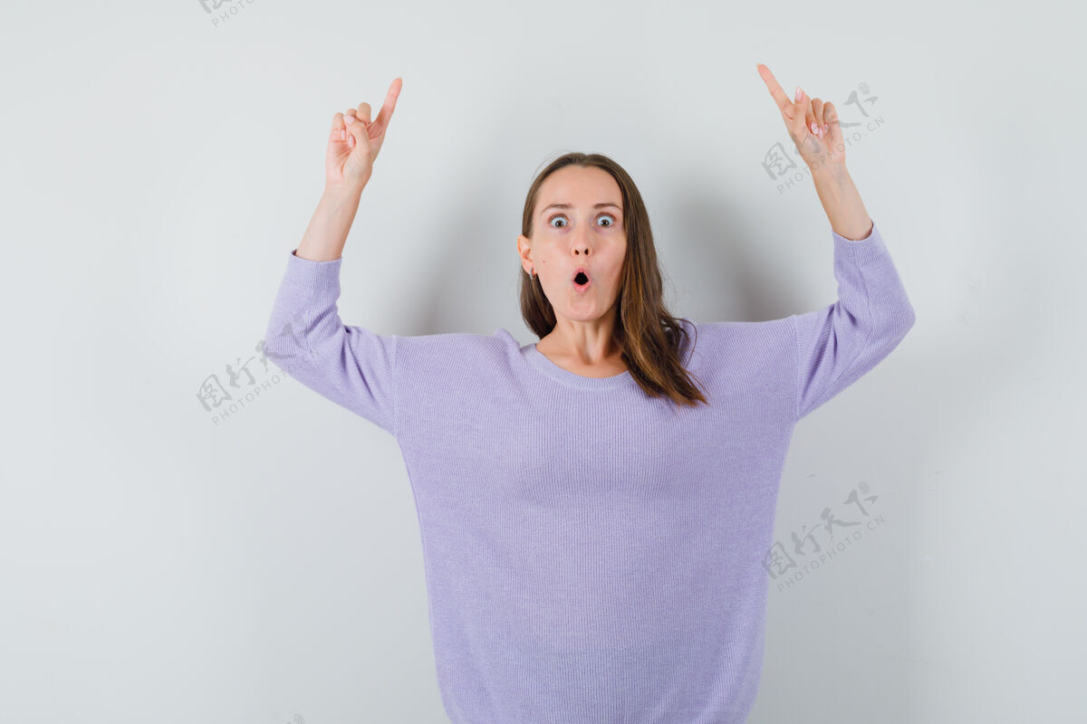 手年轻的女性指着紫丁香衬衫 看起来很惊讶性感自信女士