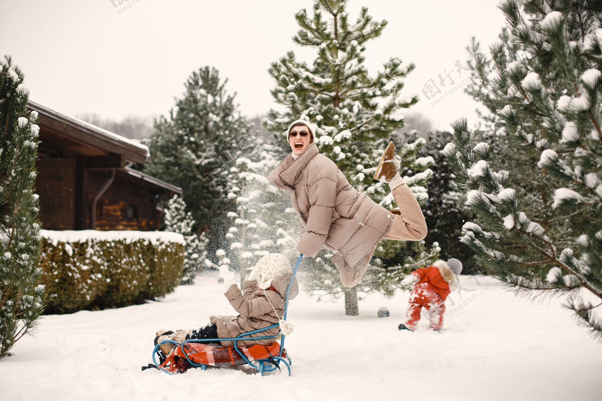 童年女人和小女孩在公园里玩雪橇太阳镜自然衣服