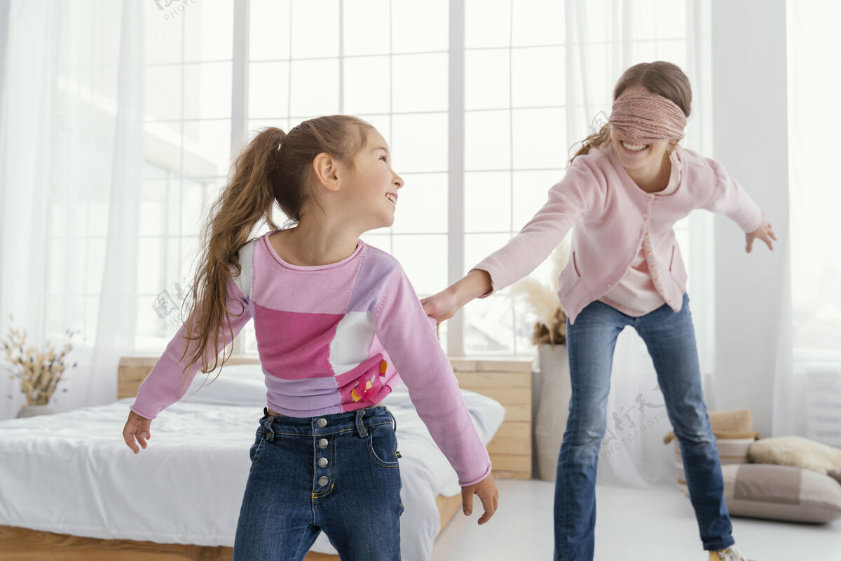 里面两个快乐的姐妹蒙着眼睛在家玩水平孩子家庭