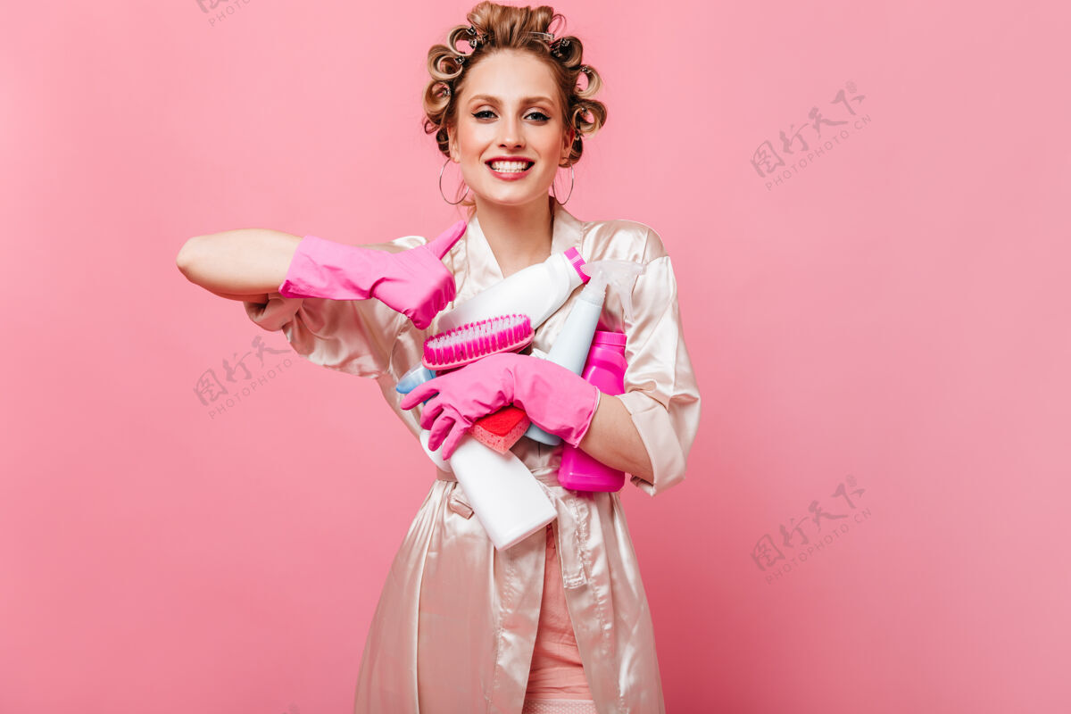 人穿着丝绸长袍的快乐女人竖起大拇指 手里拿着洗涤剂可爱卷发手套