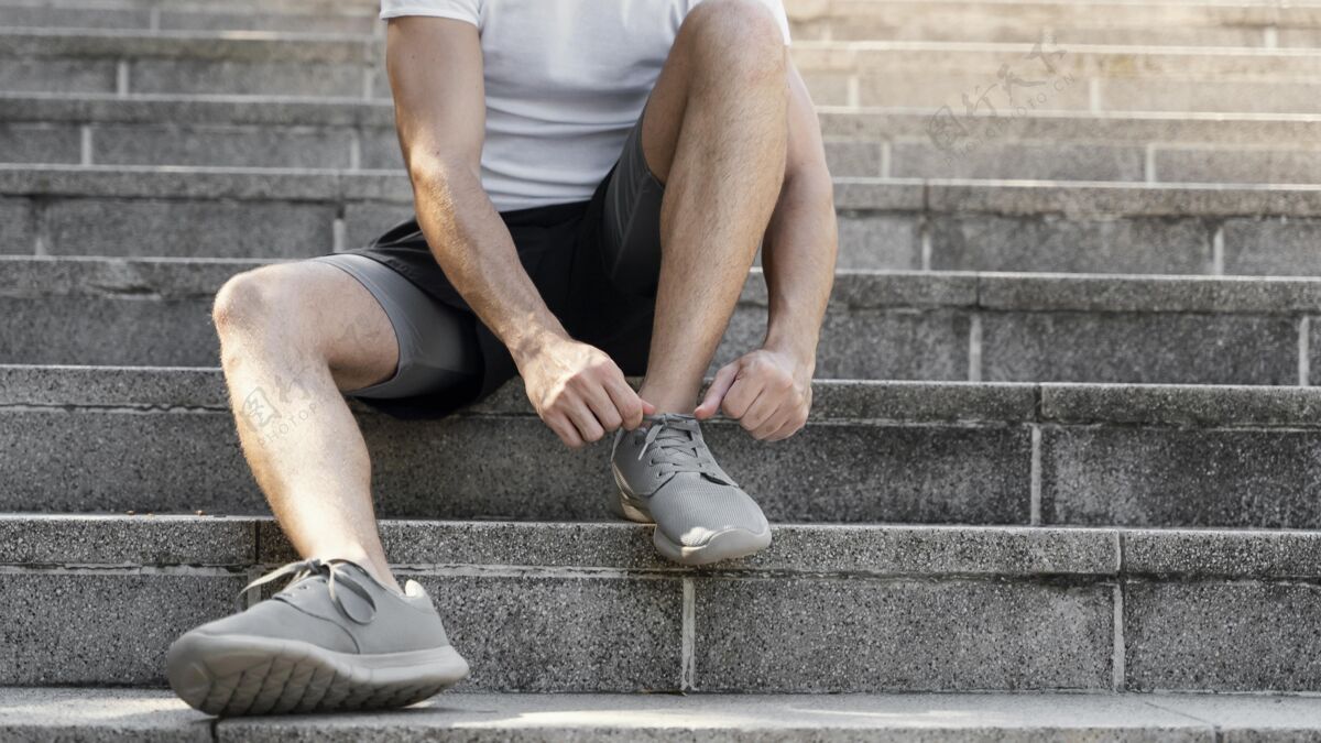 水平男人在运动前系鞋带的正面图保持健康健身活动