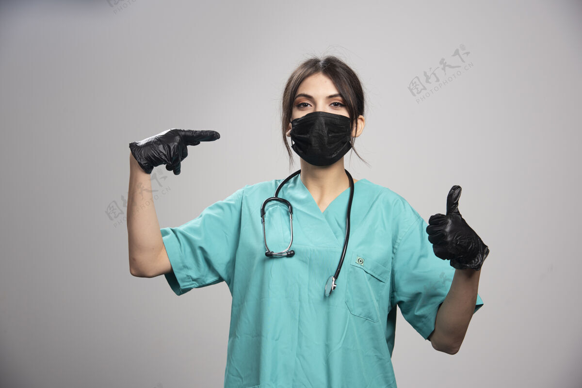 职业女医生戴着灰色的防护面具和手套女性成人医生