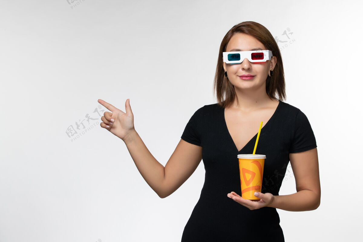 太阳镜正面图：戴着d型太阳镜拿着苏打水的年轻女性 白色表面上带着微笑女电影举行