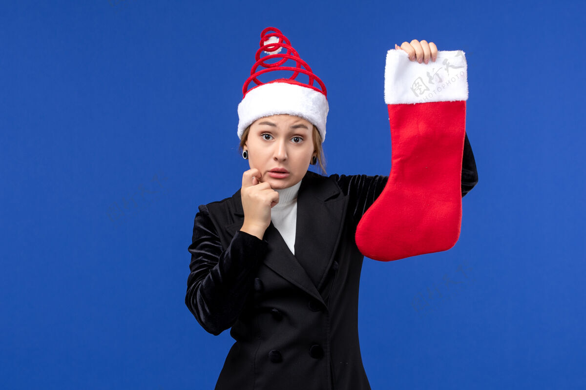 商人正面图年轻女子手持圣诞袜在淡蓝色的墙上过年工人爱国执行