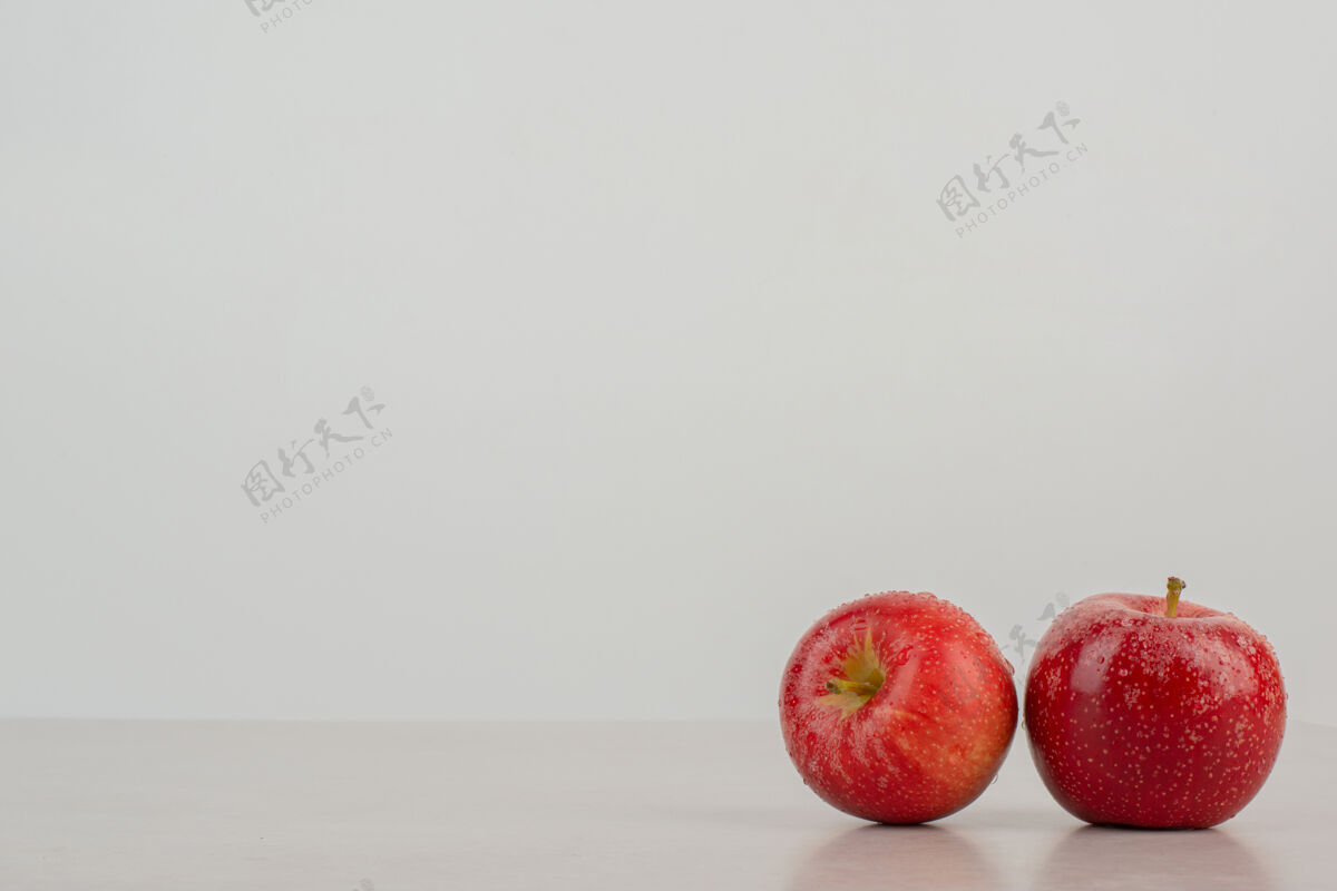 多汁大理石桌上有两个红苹果美味背景红色