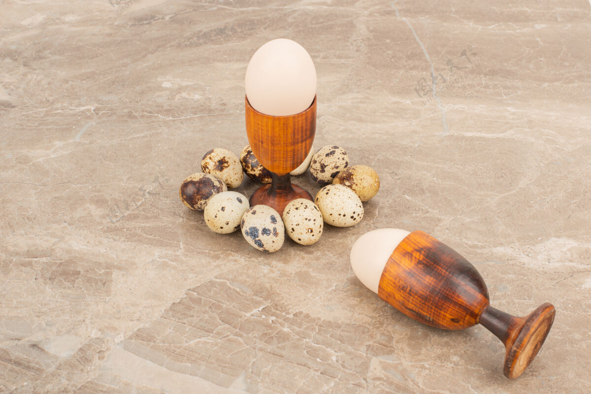 生鸡蛋几只鹌鹑蛋围着白蛋放在大理石桌上鹌鹑蛋壳生鸡蛋