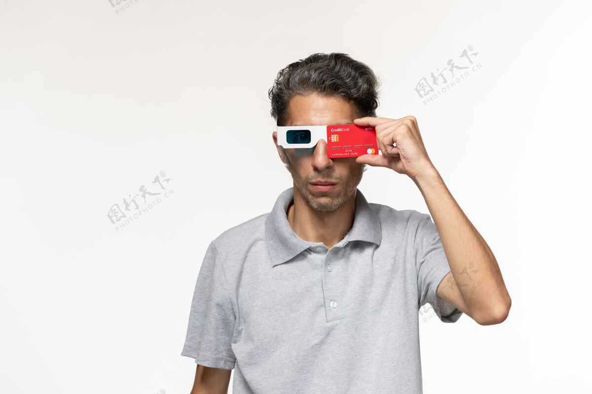 胡子正面图年轻男子手持红色银行卡 戴着d墨镜 在白色表面男性年轻男性远程