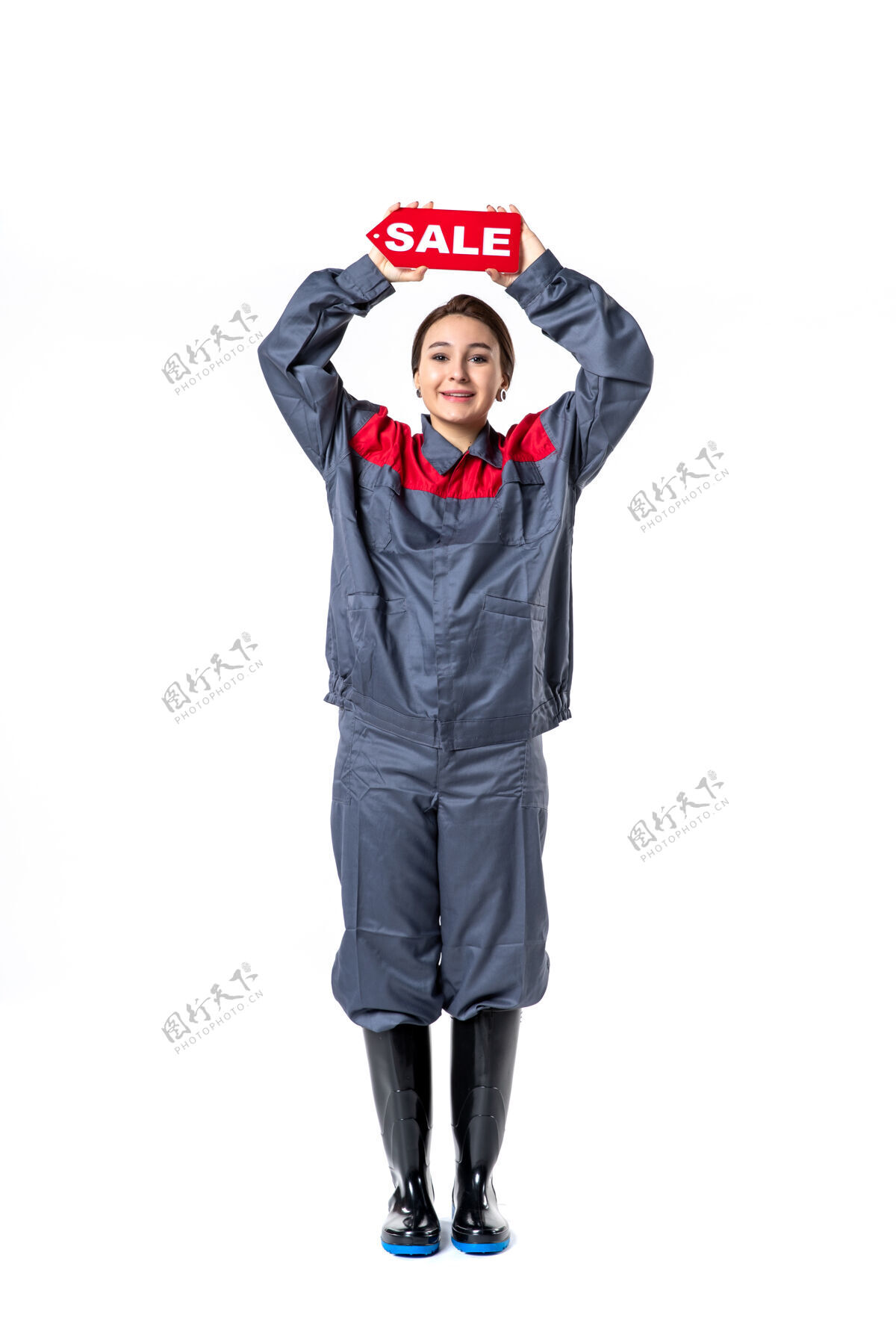 销售正面图身穿制服的年轻女性手持白色背景上的红色销售铭牌女人年轻女性专业