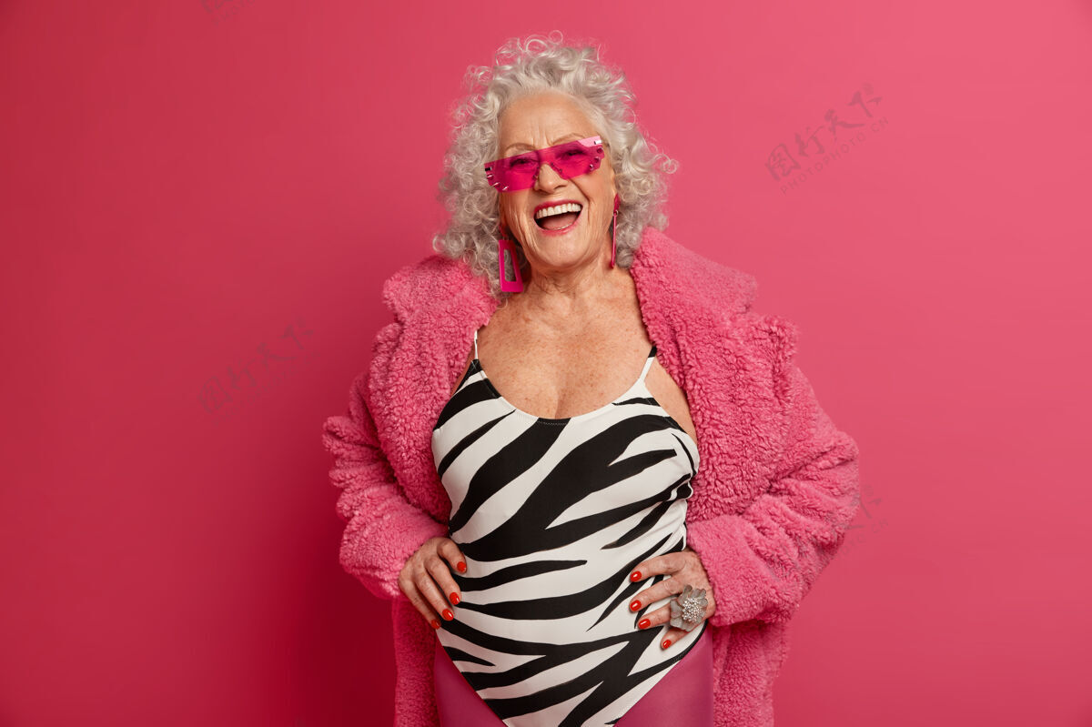 微笑穿着粉色紧身衣和外套 满脸皱纹的时尚老奶奶的特写照片室内退休老年人