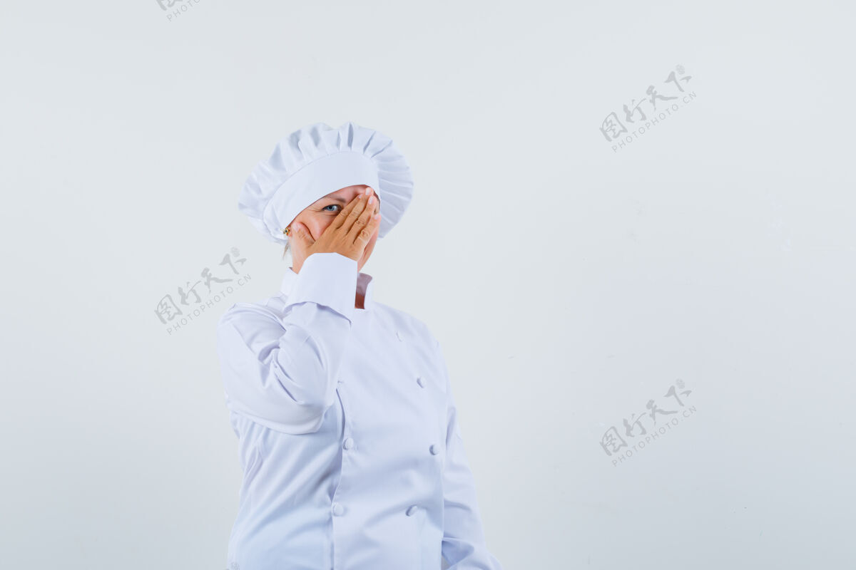 可爱一个穿着白色制服的女厨师从她的手上看过去 看起来很隐蔽年轻隐藏制服
