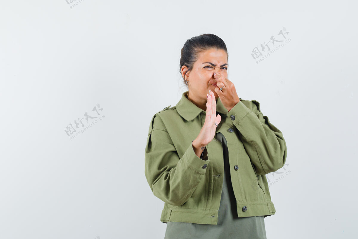 治疗穿夹克衫 t恤衫的女人因气味难闻而捏鼻子 看起来很恶心皮肤鼻子肩膀