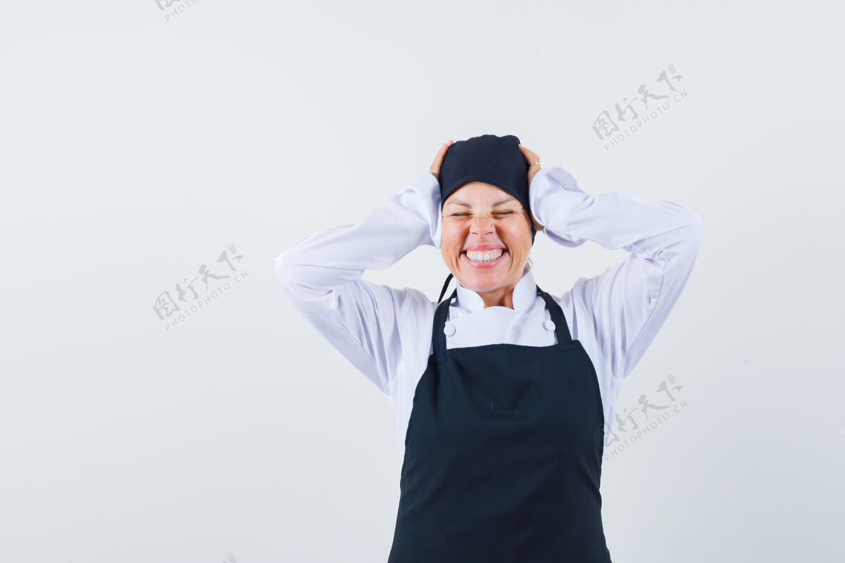 可爱穿着黑色厨师制服的金发女人双手贴在耳朵上 闭上眼睛 看起来很漂亮皮肤手金发