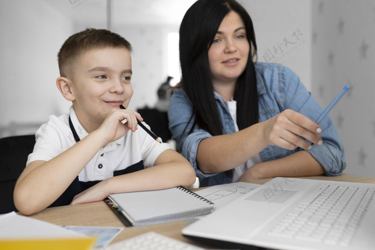 讲座中镜头笑脸女人和小孩用笔记本电脑男孩教育在线学习