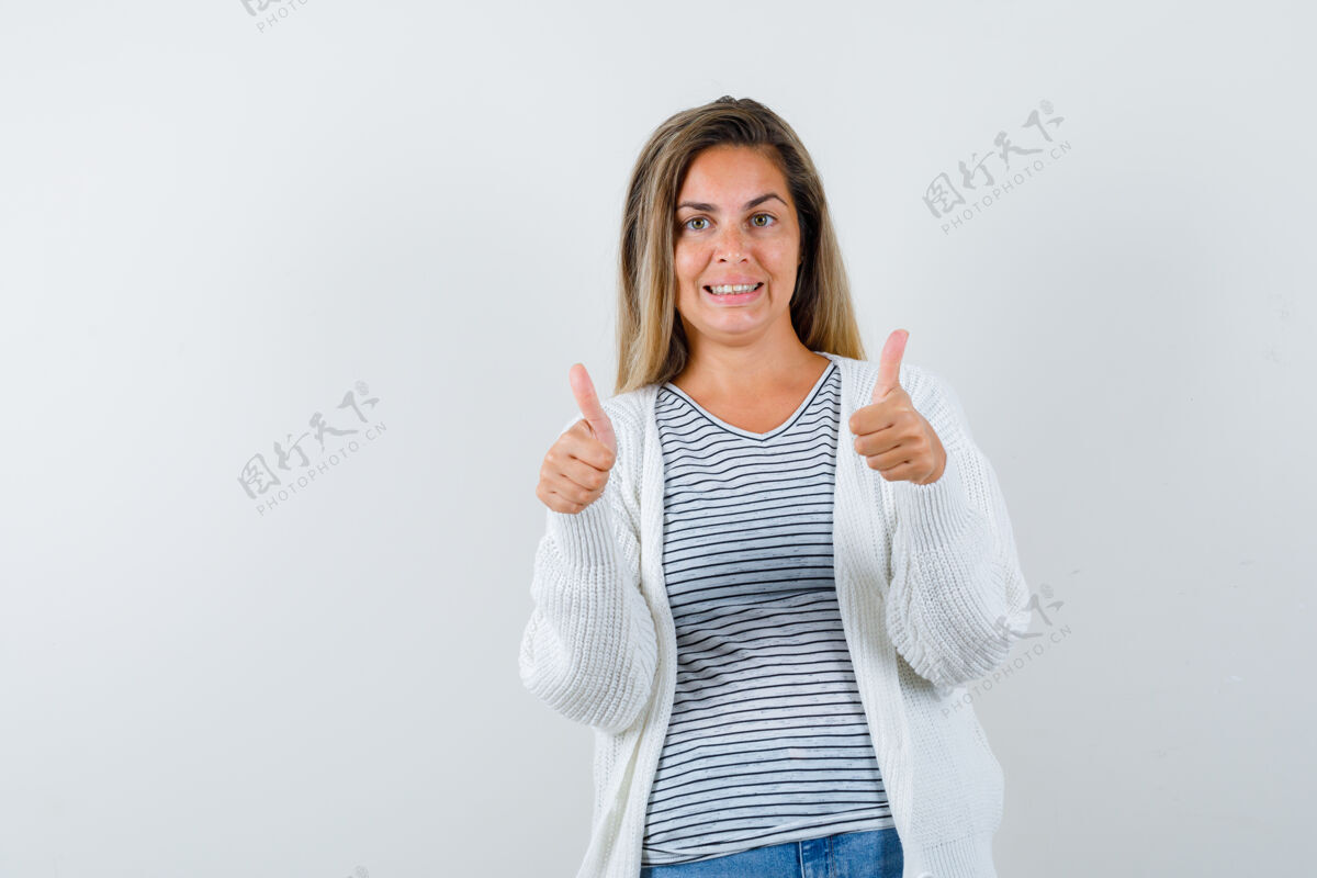 人穿着t恤衫的年轻女士 夹克衫上竖起了大拇指 看上去很快乐 正前方是风景拇指双人快乐