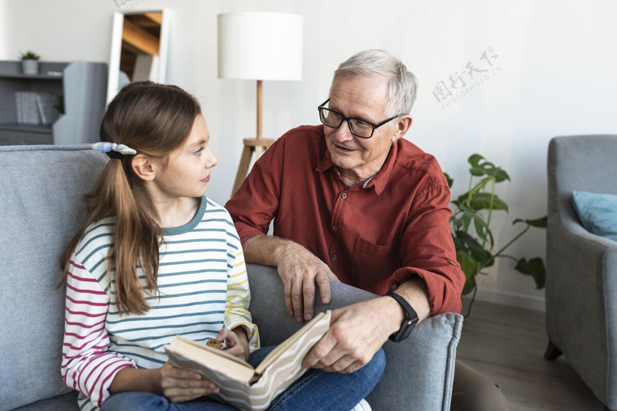 老年人爷爷和女孩拿着书在家老年人室内