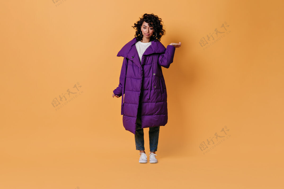 外套一个穿着紫色羽绒服的有趣的年轻女人在看前面女性冬季人