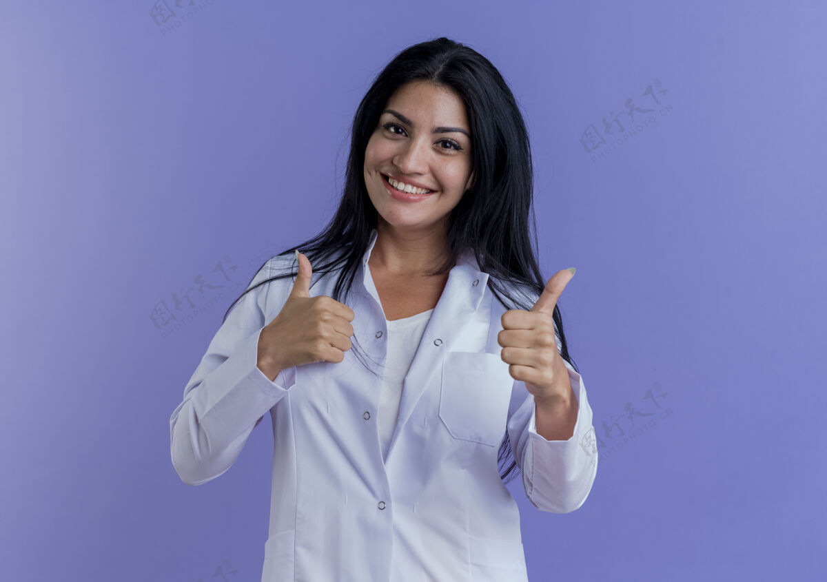 专业面带微笑的年轻女医生穿着医用长袍 竖起大拇指长袍健康制服