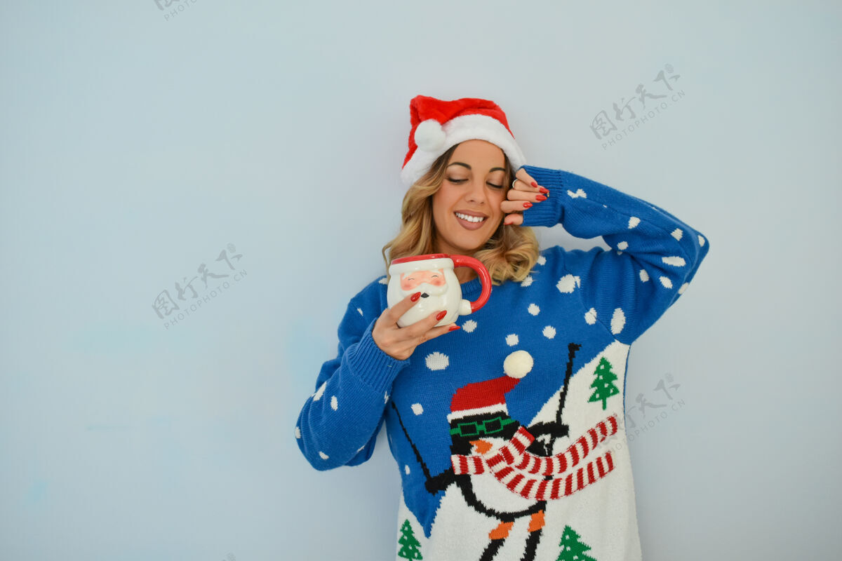 颜色特写镜头一个美丽的年轻女士穿着圣诞礼服和帽子举行圣诞老人杯圣诞节漂亮女士
