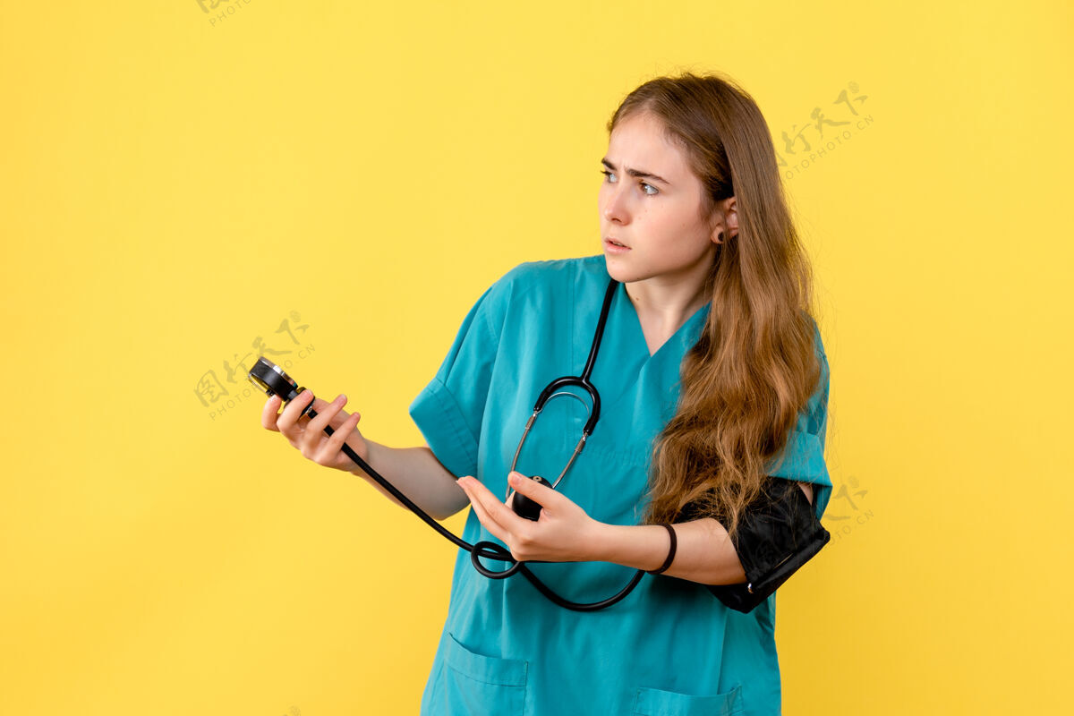医生前视女医生测量压力黄背景卫生院医护人员听诊器护理护士