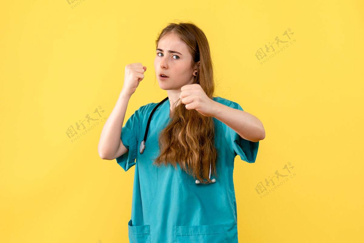 漂亮正面图女医生在黄色背景上摆出斗士姿势医院健康感慨姿势斗士女医生