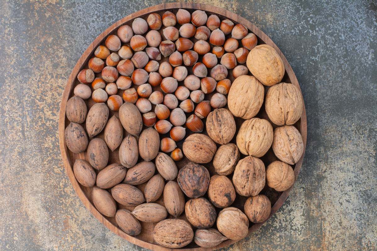 盘子木质碗上有营养的棕色混合坚果高品质照片种子美食健康