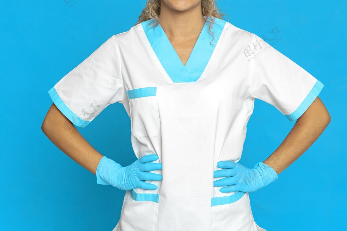 吸引力靠在蓝色墙上的护士的照片外科医生性感时尚