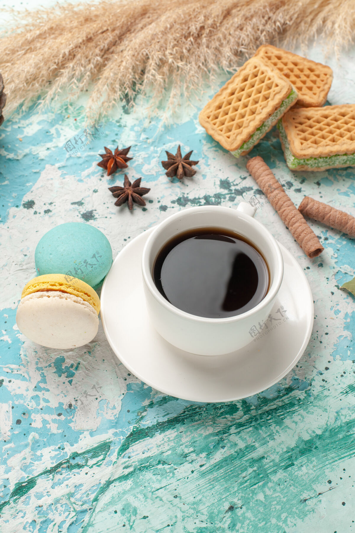 马克杯前视图华夫饼和麦卡龙配一杯茶在蓝色表面蛋糕饼干糖甜饼干视野咖啡咖啡因