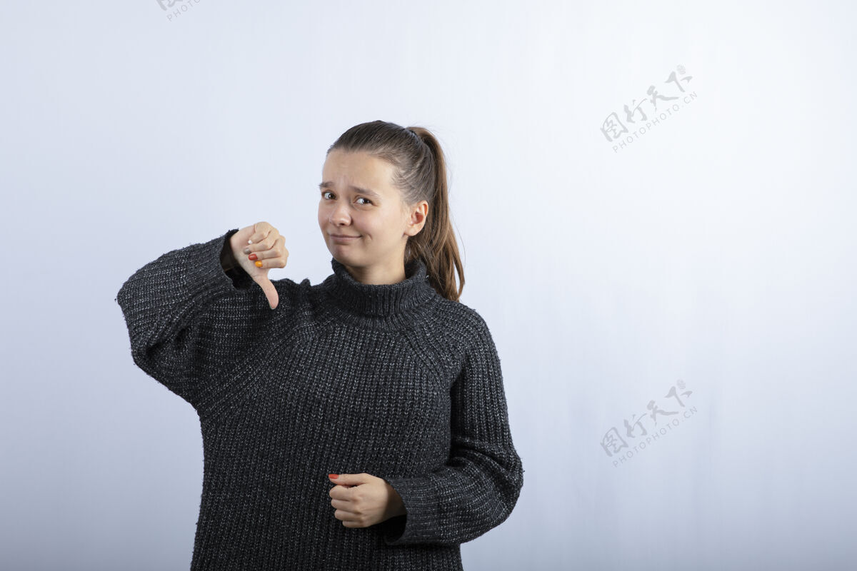 女人美丽的年轻女孩向灰色竖起大拇指的照片模特长相女人