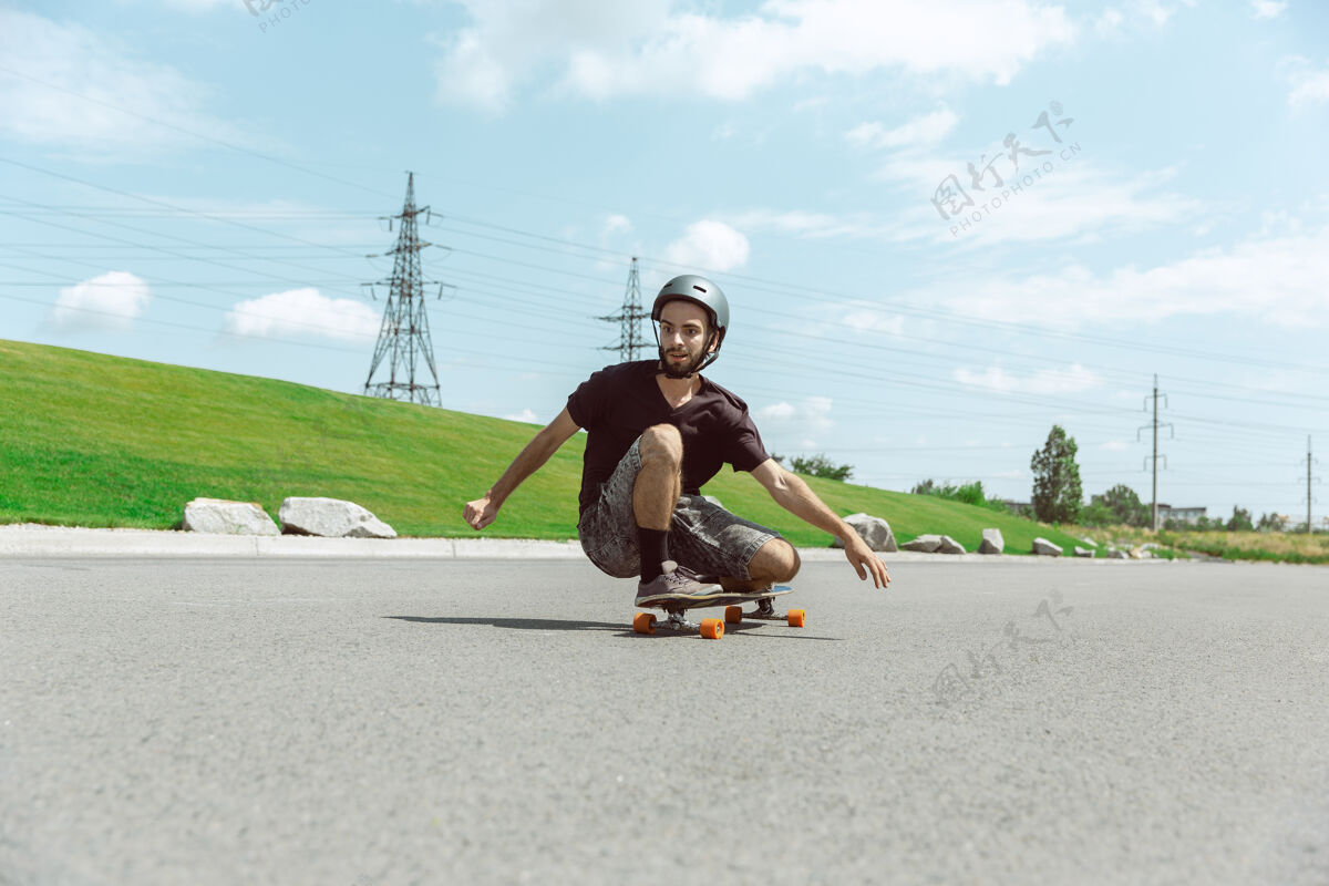 练习在阳光明媚的日子里 滑板手在城市的街道上玩花样休闲极限男孩