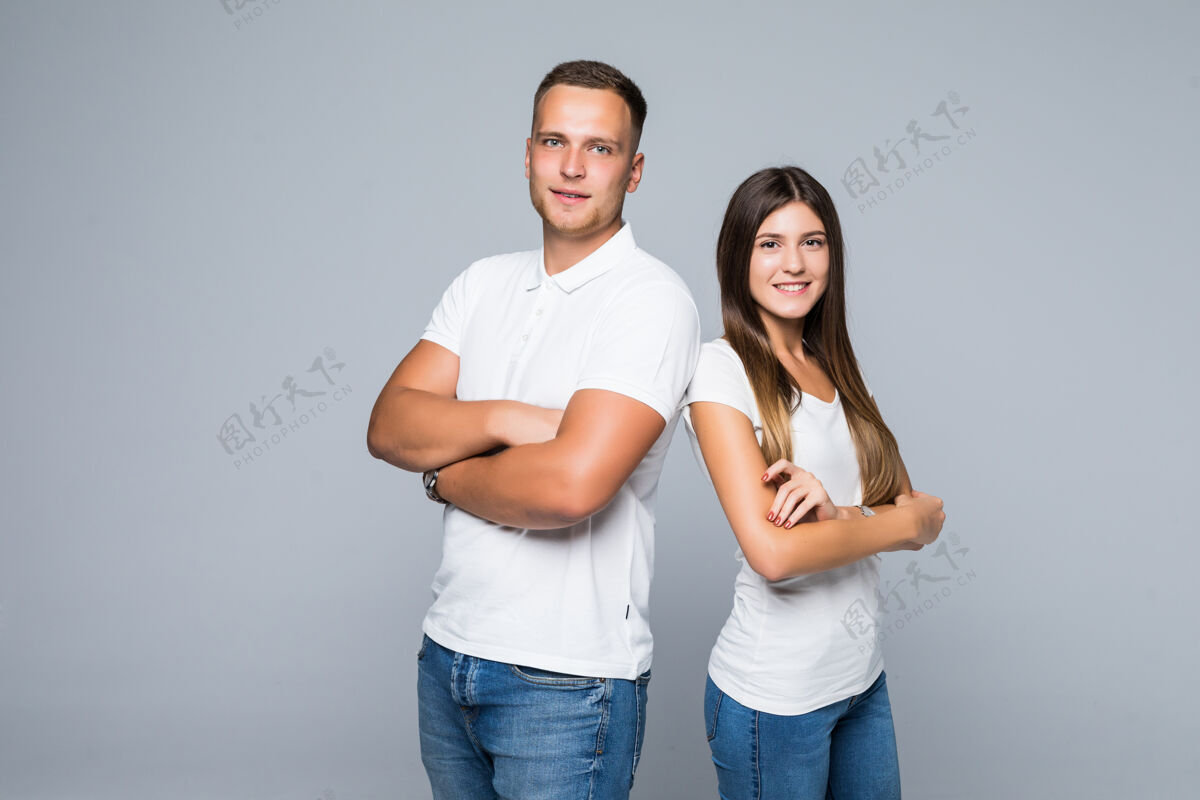 欢呼可爱的年轻微笑情侣学生工作室孤立的白色T恤牛仔裤拥抱关系手情爱