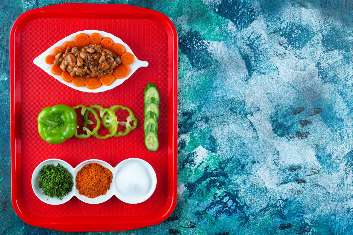 顶视图把胡萝卜 豆子和蔬菜放在盘子里 放在蓝色的盘子里胡椒蔬菜风味