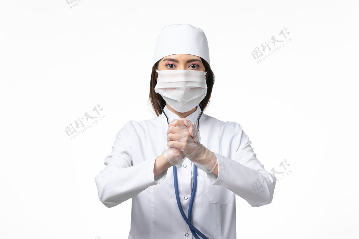 疾病正面图女医生身穿白色无菌医疗服 带口罩 因白墙上有冠状病毒病大流行冠状病毒预防正面大流行