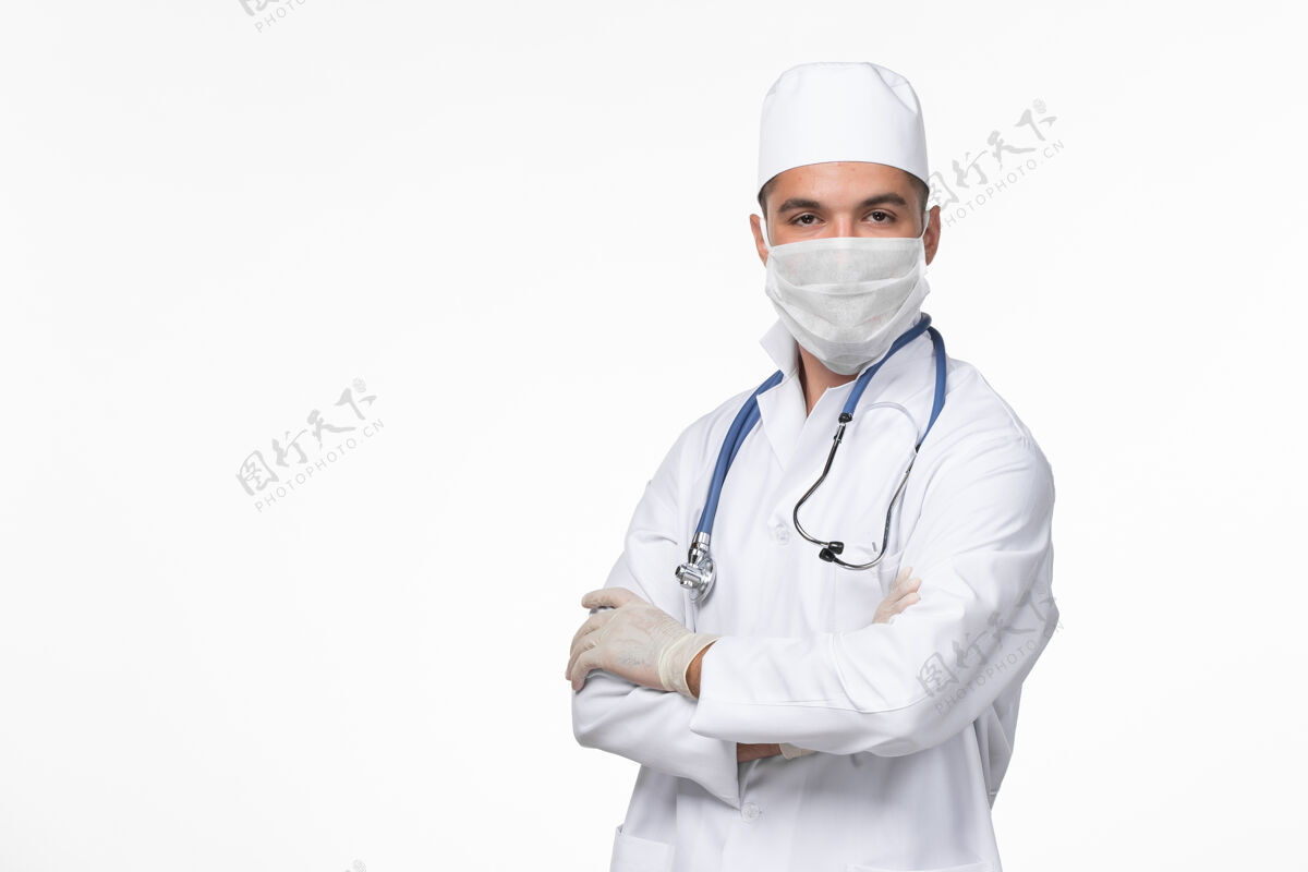 医疗正面图：男医生穿着医疗服 戴着口罩 对抗白墙病毒-病毒-疾病大流行药听诊器疾病