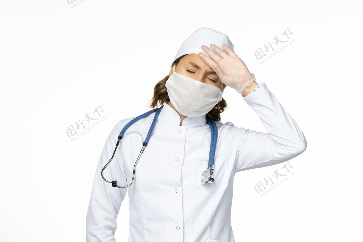 护士白壁上穿着白色医疗服 戴着头痛面具的女医生pandemy病毒病药听诊器制服前面