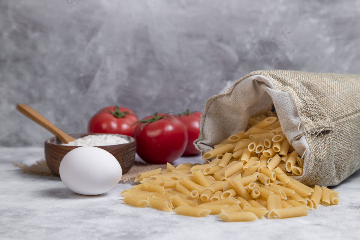 素食一袋干巴巴的意大利通心粉配上红番茄和面粉Fusilli自制的餐桌