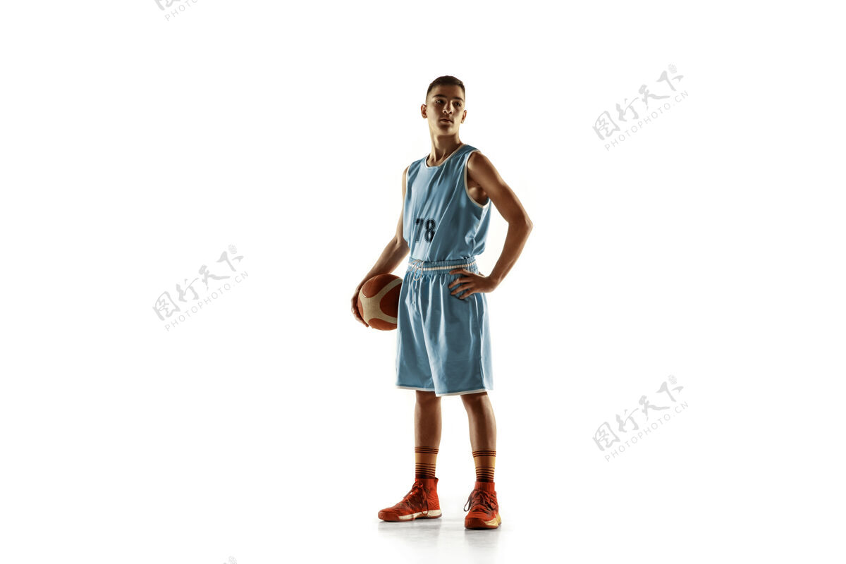 运动员一个年轻的篮球运动员与一个球在空白处孤立的全长肖像游戏健身动作