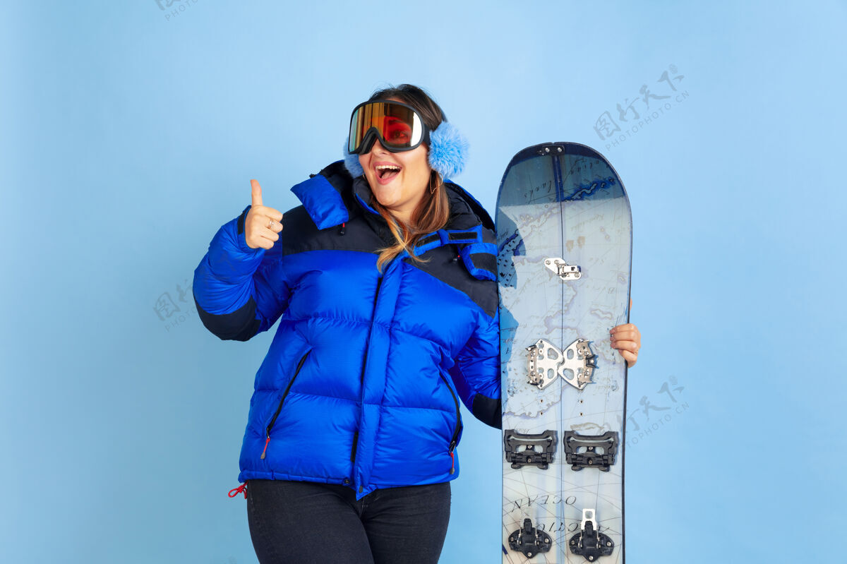 专业滑雪板蓝色空间上的白种女人肖像穿着暖和衣服的漂亮女模特情绪金融现代