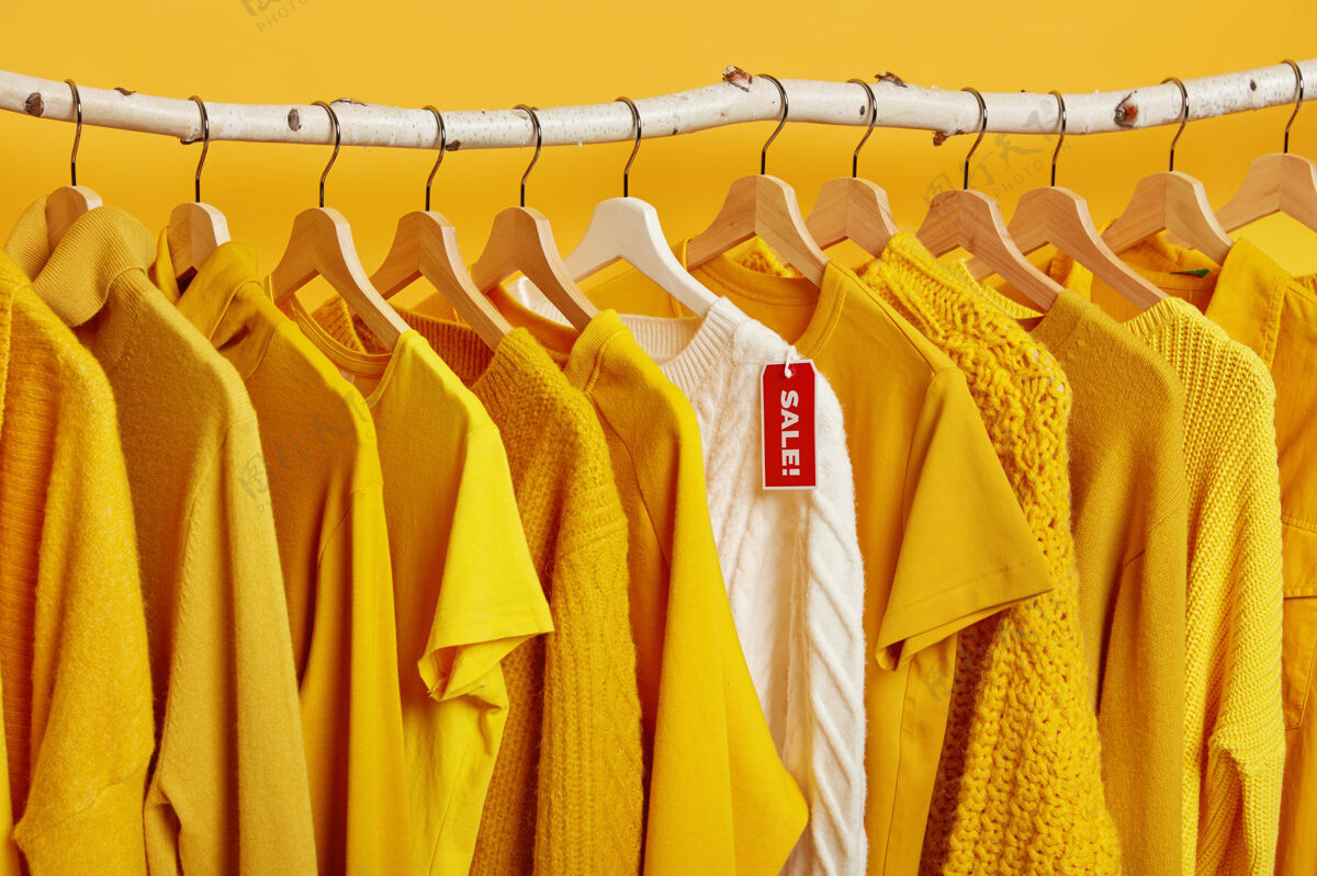 黄色服装店清仓大甩卖毛衣大折扣带标签的衣架上有针织套头衫整洁套装零售