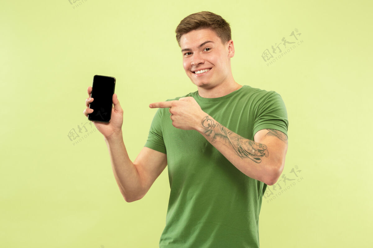 人类白人年轻人在绿地上的半身肖像穿着衬衫的漂亮男模手广告金融