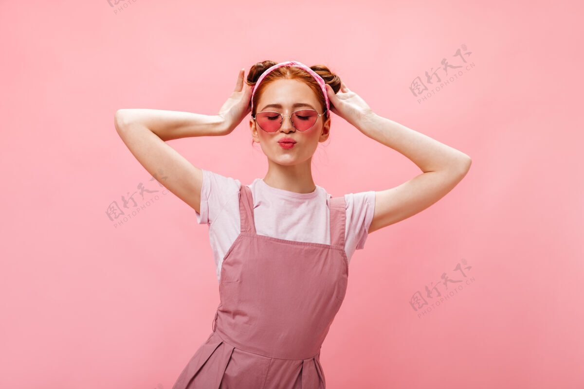 粉色背景可爱的女人 带着小面包 穿着粉色工装裤和白色t恤 在粉色背景下闭着眼睛摆姿势白色t恤眼睛化妆品
