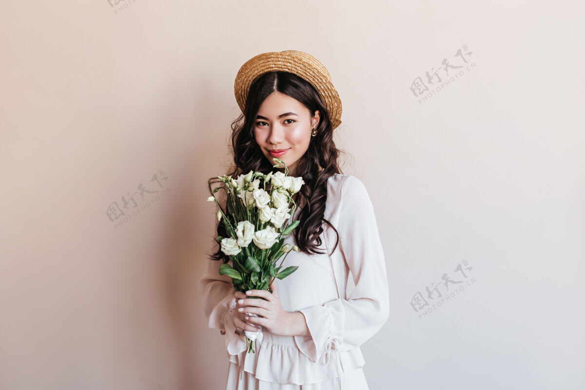 服装令人惊奇的卷曲的日本女人拿着桔梗花害羞的亚洲女人带着花束的摄影棚拍摄快乐美丽波浪发