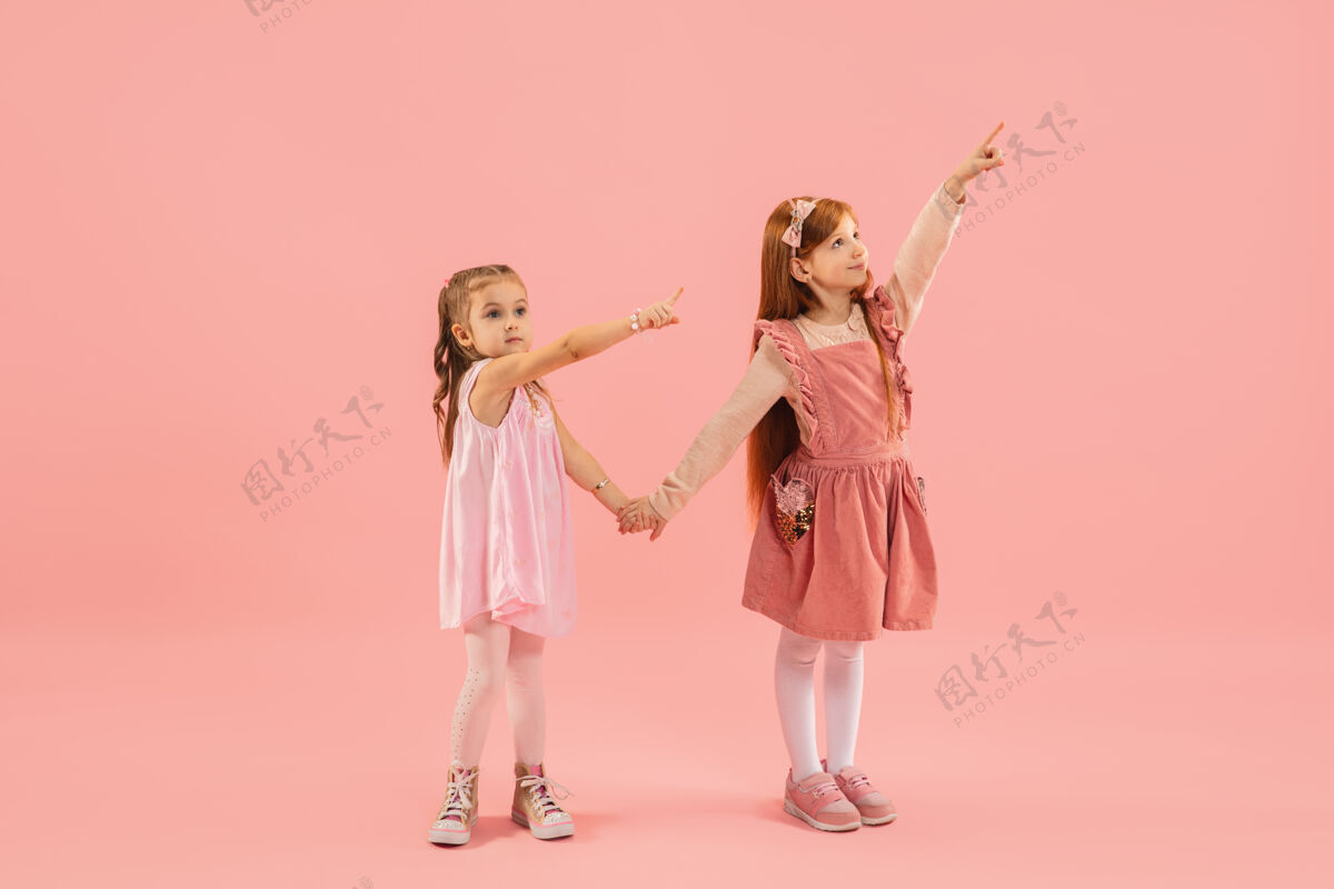 漂亮小女孩指着粉红色的墙上可爱人未来