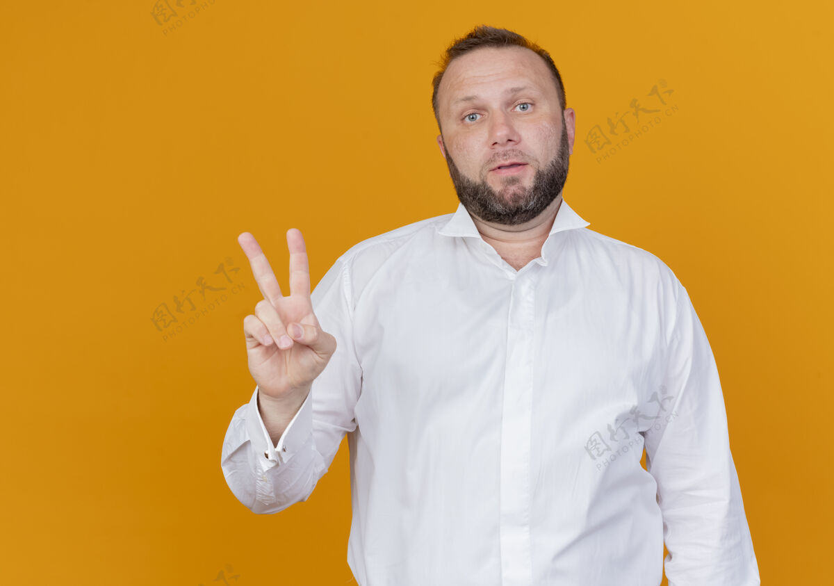 胡子一个留着胡子的男人穿着白衬衫 站在橙色的墙上 上面写着二号人物穿看站