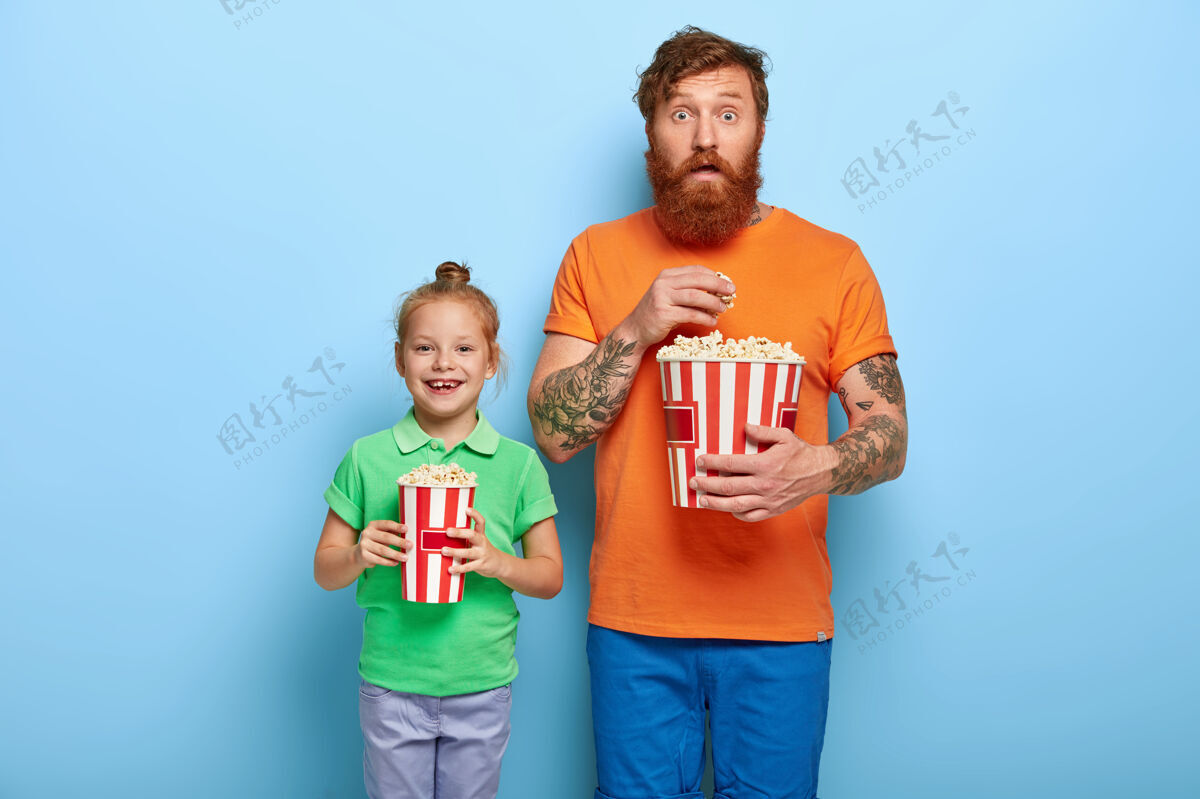房子快乐的红发孩子和她的爸爸捧着一桶桶美味的爆米花小电影小吃